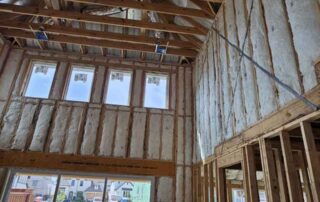 Fiberglass batt insulation on two-story wall and ceiling. Fiberglass batt insulation on two-story wall and ceiling near sliding glass door by Hayes Insulation in Dallas, TX.