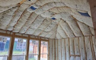 Close-up of fiberglass batt insulation on vaulted ceiling. Close-up of fiberglass batt insulation on vaulted ceiling and rafters by Hayes Insulation in Dallas, TX.