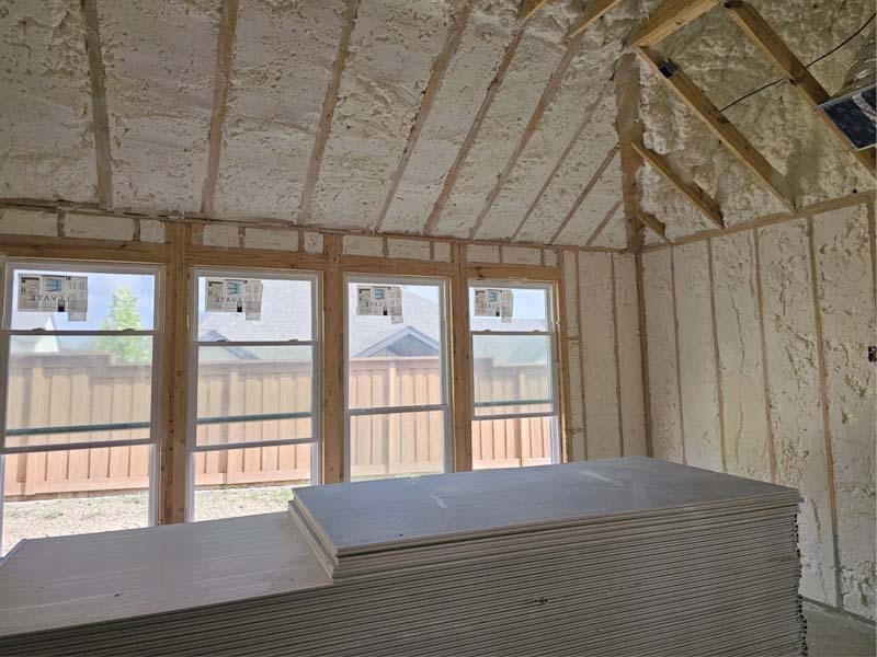 6" open-cell spray polyurethane foam insulation along roofline and exterior walls with windows by Hayes Insulation at 3322 Fulmar Circle, Frisco, TX.